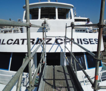 Walkway pointing towards the front of Cruise boat's 2nd floor. Visible is a large 