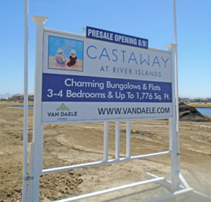 Blue and white sign on wood skid advertising Castaway property