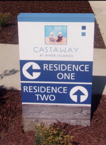 Blue and white way-finding sign directing traffic to various residences.