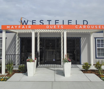 Westfield's sales trailers front facade, featuring its shaded awning, featuring it's title and community sign.