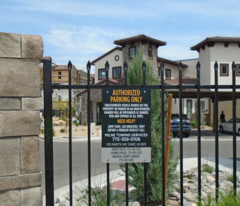 Authorized Parking only sign attached to metal rail fence.