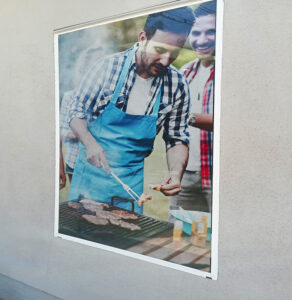Graphic of a man BBQ'ing on window.