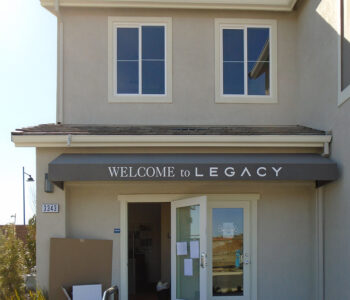 Front facade of a sales office, showing awning and doorway entrance.