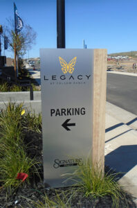 Rectangular box sign with Parking on face and arrow.